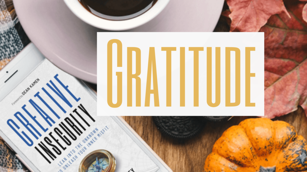 Expressing Gratitude: the word Gratitude is overlaid onto a Thanksgiving table with the book Creative Insecurity showing on a phone next to a plate.